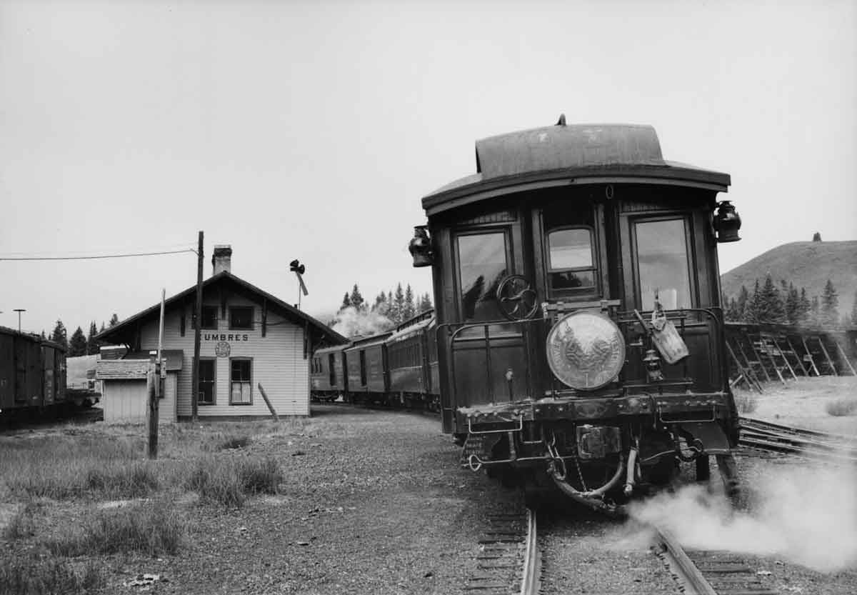 the rear of a passenger train passing a depot