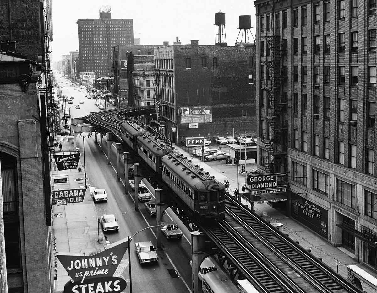 a commuter train on rails above a busy street in Chicago
