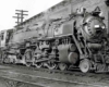 A black and white photo of a train sitting on the tracks