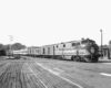 A black and white photo of a locomotive approaching a station