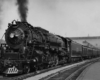 A close up black and white photo of a train with black smoke coming out of its chimney