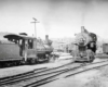 A black and white photo of two trains passing each other on the tracks