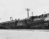 a steam engine pulling passenger cars