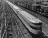 a train yard with a passenger train with the focus of the photo being the observation car