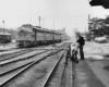 People standing on a corner watching a passing passenger train