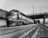 A black and white photo of a train leaving a station