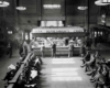 A black and white photo of people purchasing food and sitting at a terminal