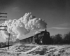 a steam engine with a huge plume of steam on a winter day