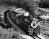 a steam engine pulling passenger cars around a curve