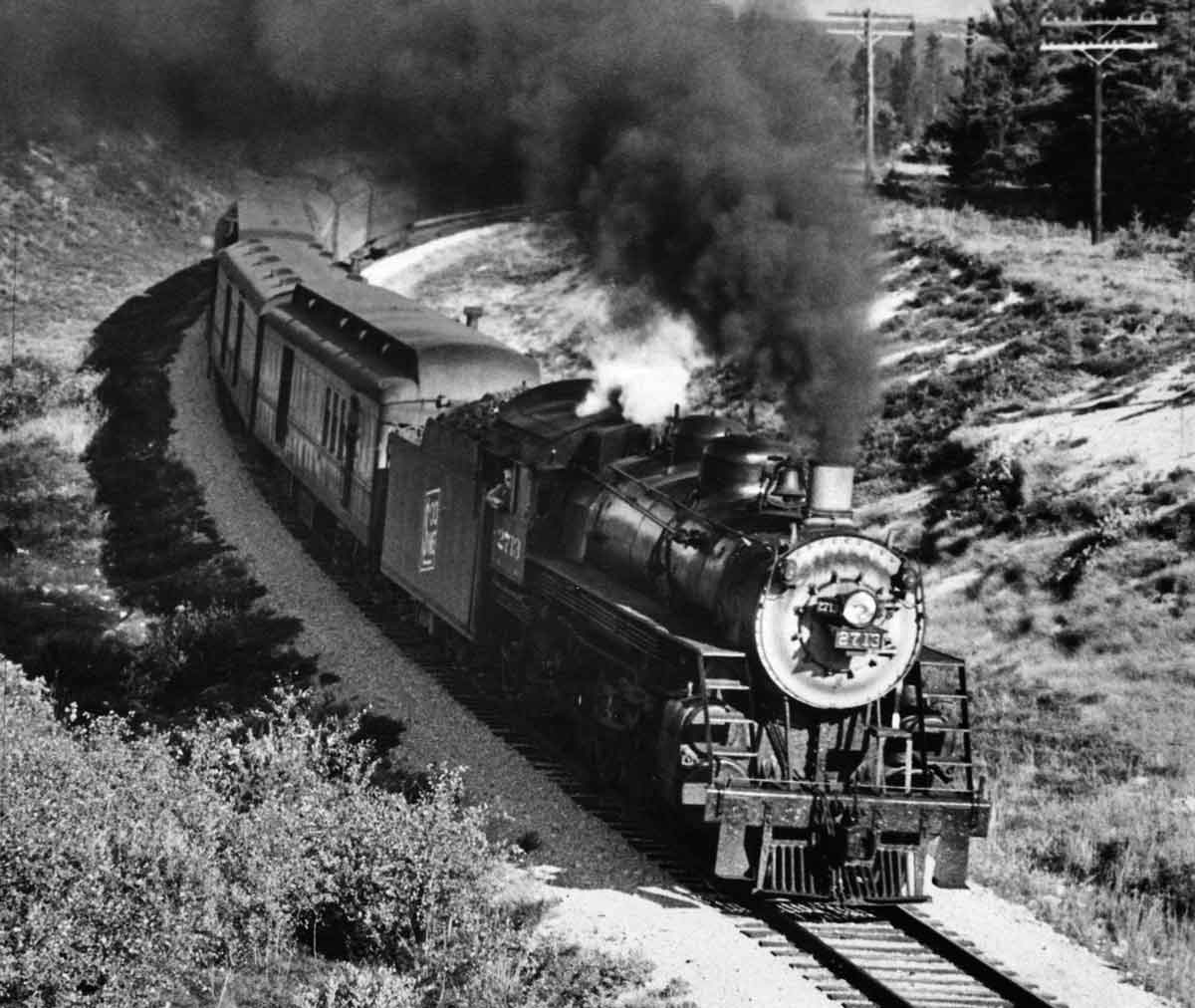 a steam engine pulling passenger cars around a curve