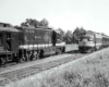 a couple of diesel passenger trains facing each other on two rails