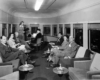 A hostess serving passengers in an observation car