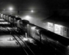 a passenger train sitting at a passenger depot on a snowy night