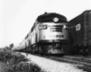 a diesel pulling passenger cars past a freight train