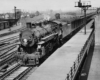 a steam engine pulling passenger cars