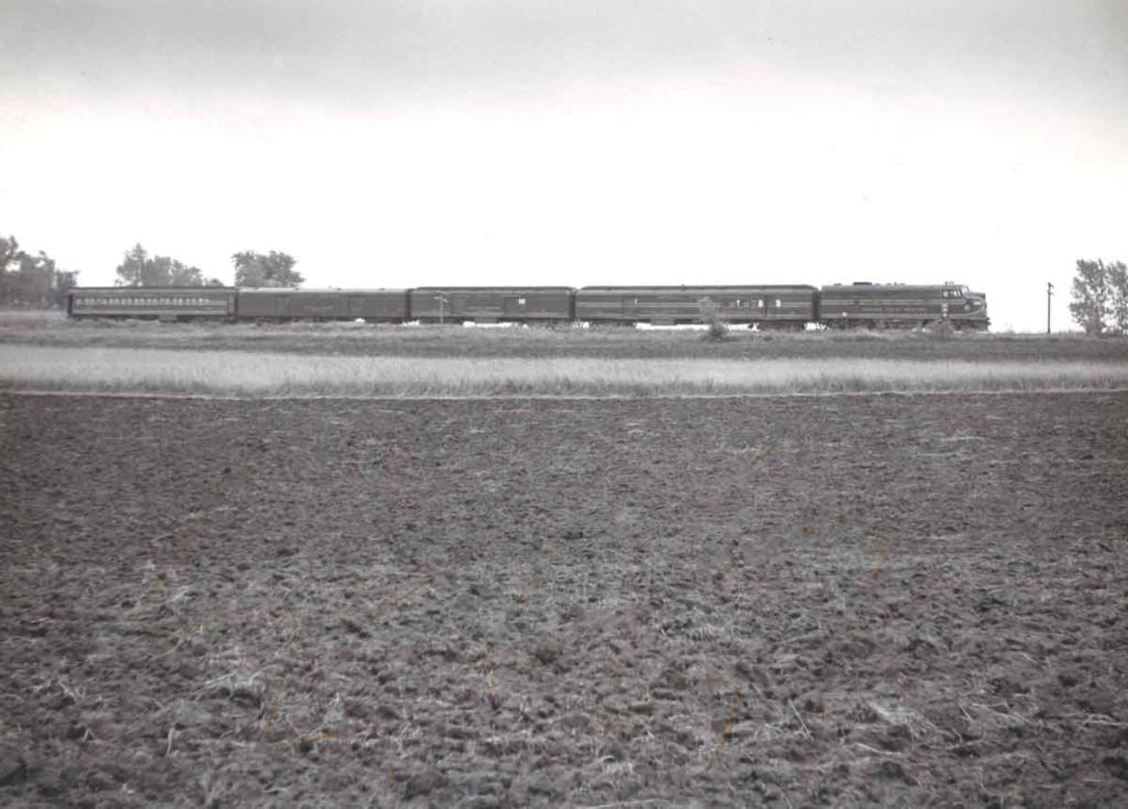 A distant black and white photo of a train passing by