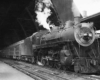 A black and white photo of a train parked inside a station