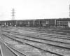 A black and white distant shot of a train arriving at a terminal