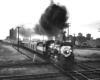 A black and white photo of locomotive 4-6-2 702 crossing a railroad intersection