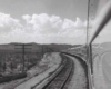 A black and white photo taken out of a window of the Texarkana–El Paso Westerner locomotive looking back at the train