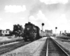 A black and white photo of locomotive 4-6-2 715 passing a stop light