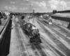 A black and white photo of locomotive 4-8-2 907 leaving the rail yard