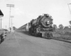 a steam engine passenger train pulling into a station