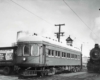 A passenger car next to a steam locomotive