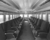 A black and white photo of the inside of a passenger car