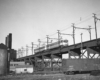 A black and white photo of a passenger car on a bridge