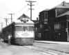 a black and white photo of a passenger car by a railroad station