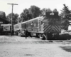 Motorcar with coach at station