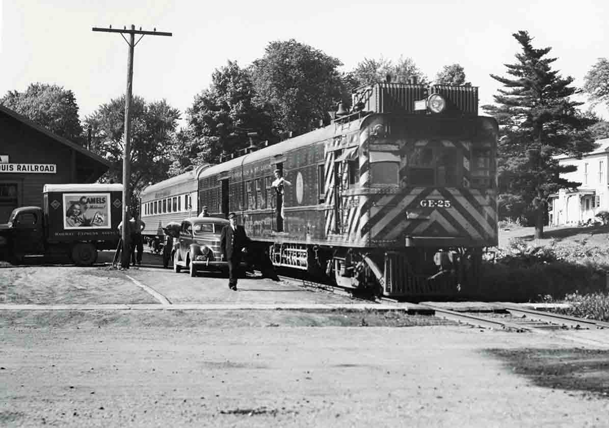 Motorcar with coach at station