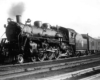 Steam locomotive with passenger train on curve under bridge