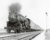 A black and white photo of a train with black smoke coming out of its chimney