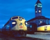 Two diesel locomotives in front of a train station