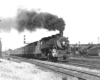 A train coming down the tracks with black smoke coming out of it