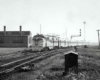 A train passing by a building and a stop light