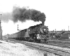 A train traveling by with black smoke coming out