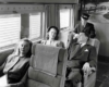 Three passengers relaxing on a train