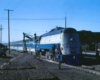 A blue and white train with two workers working on it
