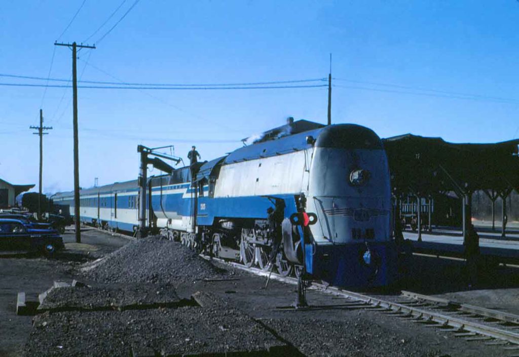 A blue and white train with two workers working on it