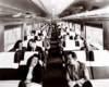 A  black and white photo of passengers sitting in a train