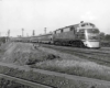 Diesel locomotive with four passenger cars on elevated curve