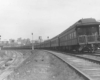 Rear of passenger train on curve by yard with signals