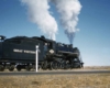 A train passing by with two guys looking out the window of the train