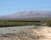 Big boy captured from a distance, turning a cover, with mountains in the background