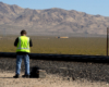 A worker standing next to the tracks as big boy approaches in the distance