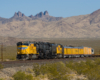 Big boy coming down the tracks with mountains in the background