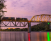 A train passing over a bridge during sunset